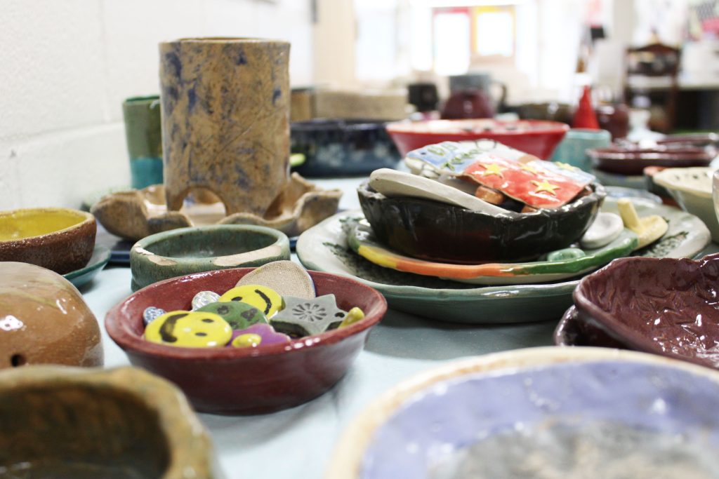 Finished pottery pieces are placed on the blue tables